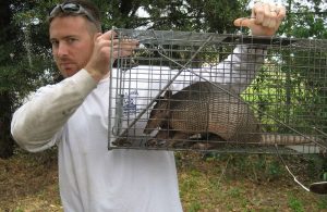 Hombre sosteniendo una jaula que atrapó el armadillo