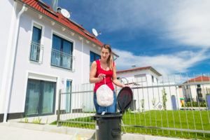 Mujer con guantes de plástico y tirar la basura fuera