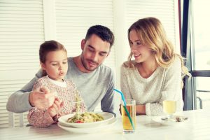 Familia feliz comiendo pasta en la mesa