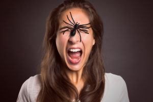 Mujer con araña en la cara.