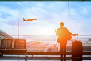 Una mujer con maleta está esperando su vuelo en la sala de salidas