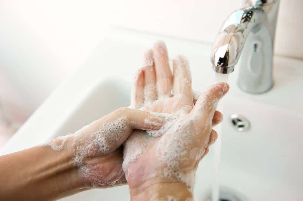 Un hombre está lavando sus manos con jabón
