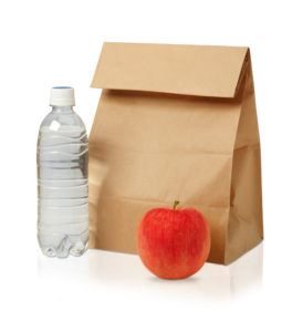 primer plano de la bolsa de almuerzo de papel marrón, manzana roja y botella de agua aislada en blanco.