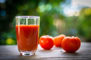 tomates y jugo de tomate en la mesa de madera.